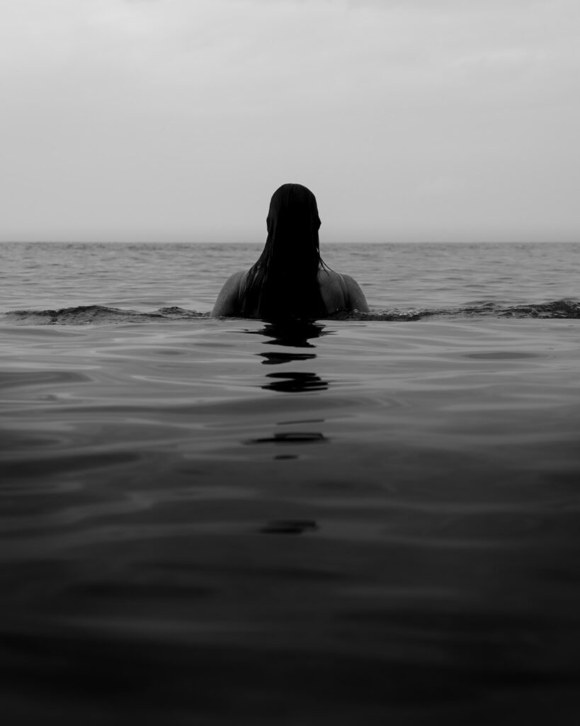 faceless woman in calm ocean water