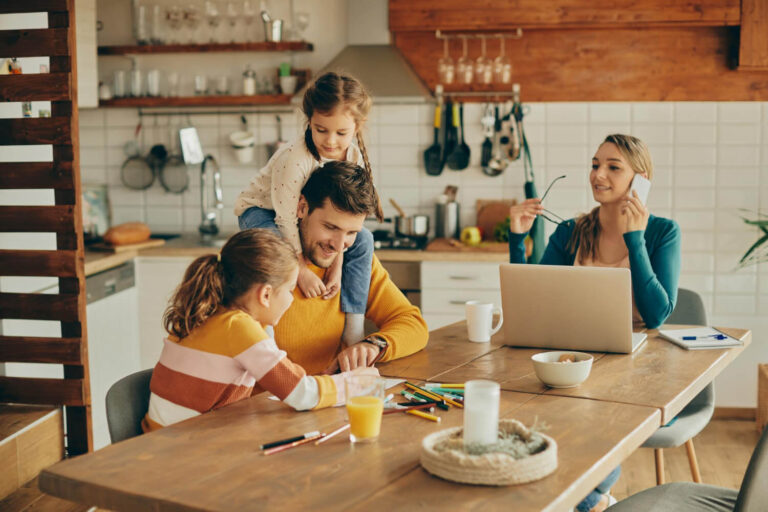 happy father having fun with daughters while mother is working home