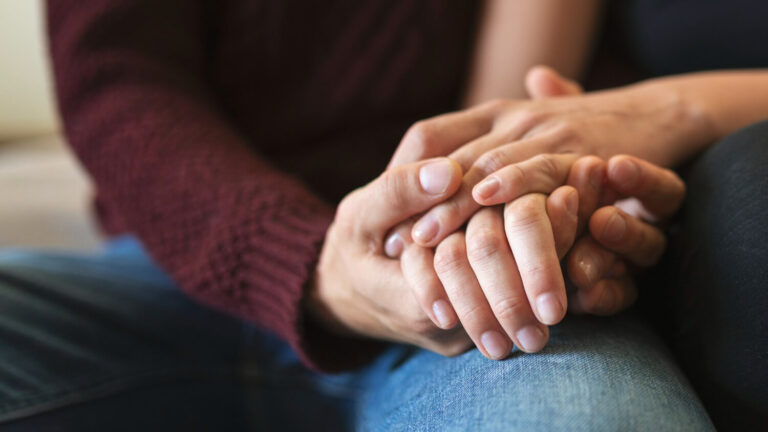 passionate couple holding hands bed