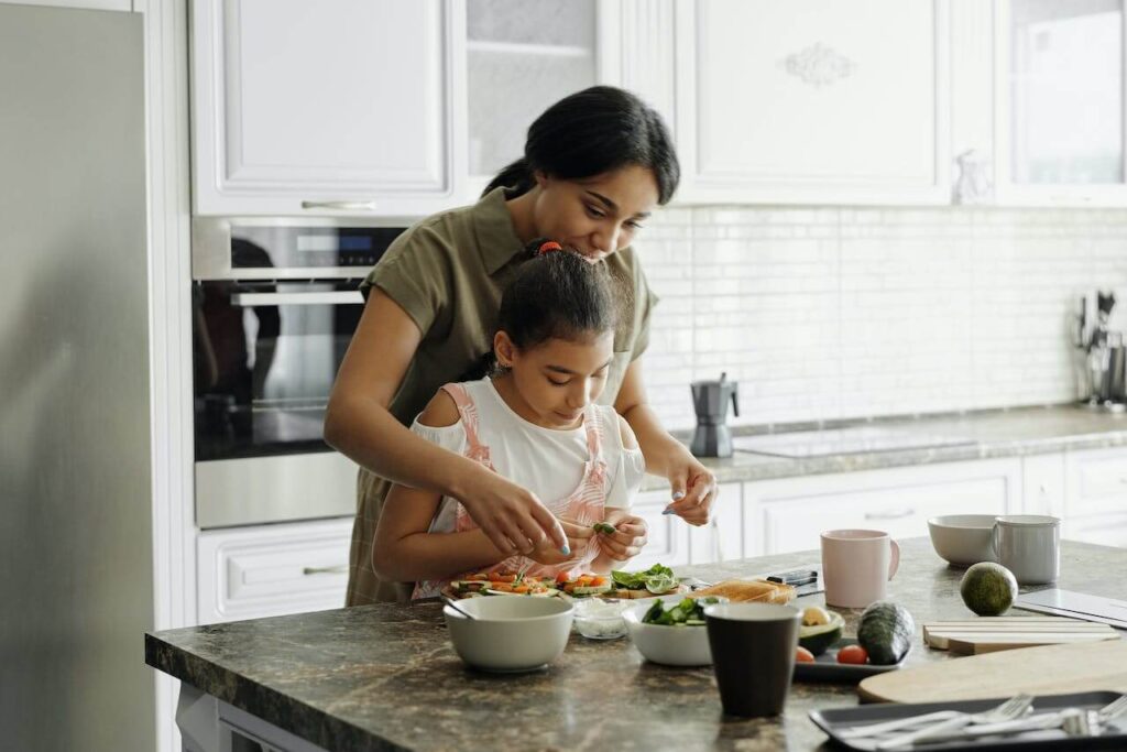 mother and daughter preparing avocado toast