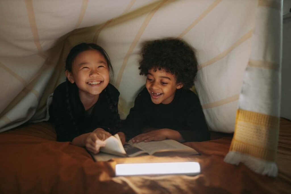 girl and boy having fun while reading a book