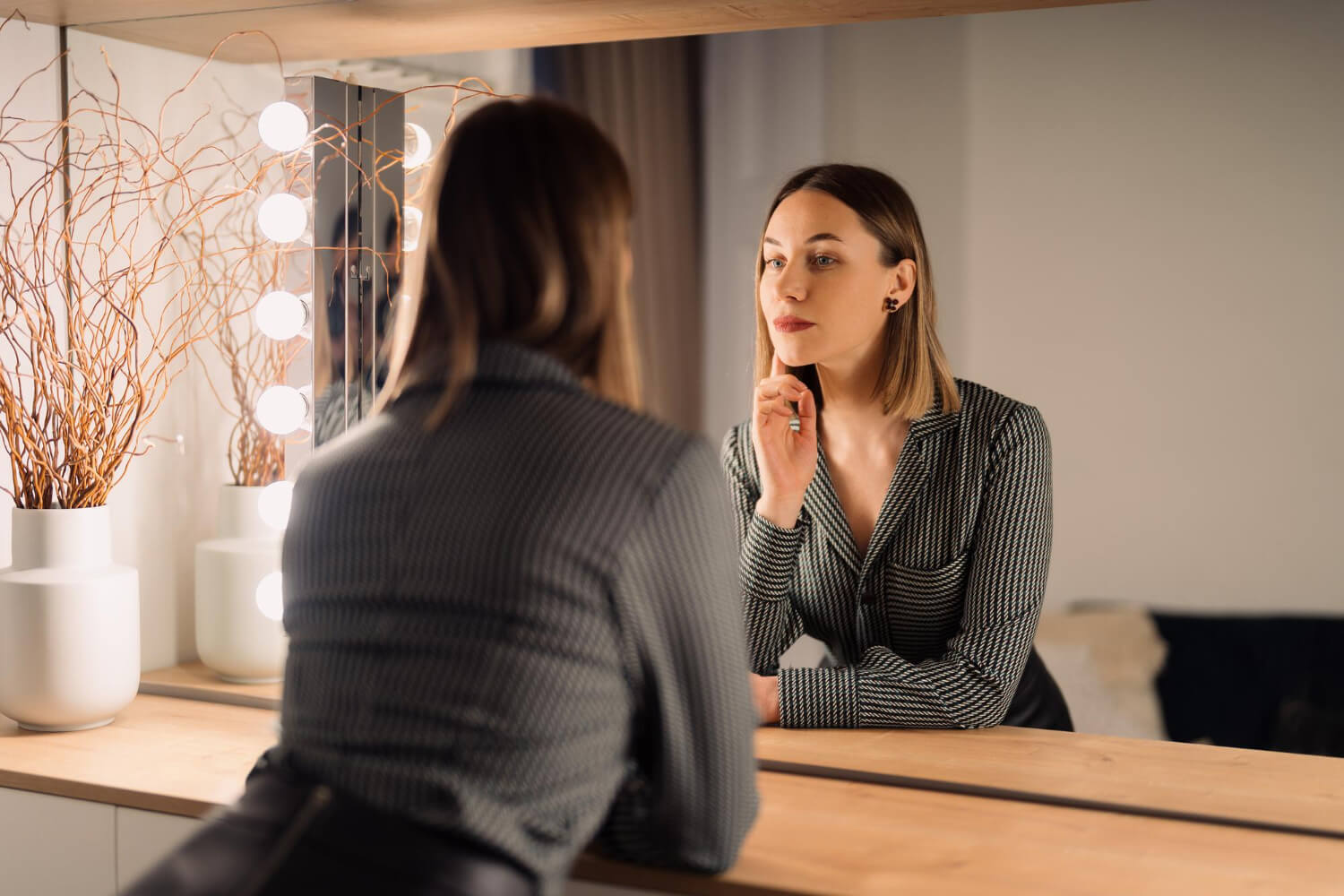 self confident woman looking her reflection into mirror indoors beautiful interior design