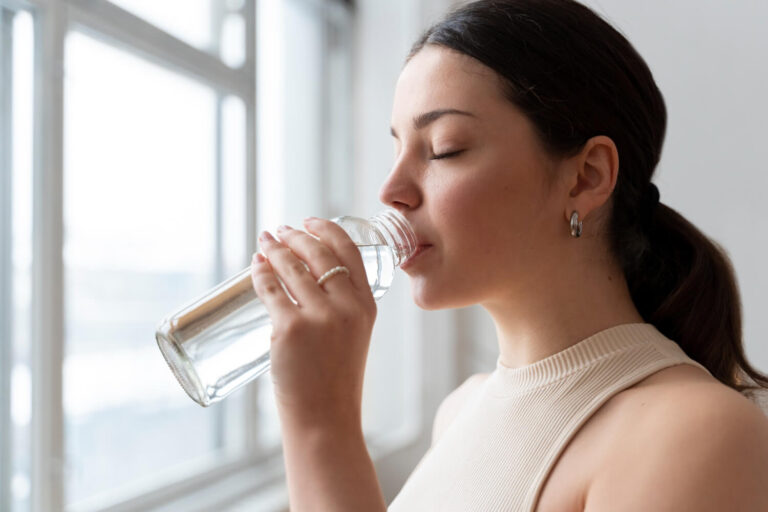 woman drinking water after exercise