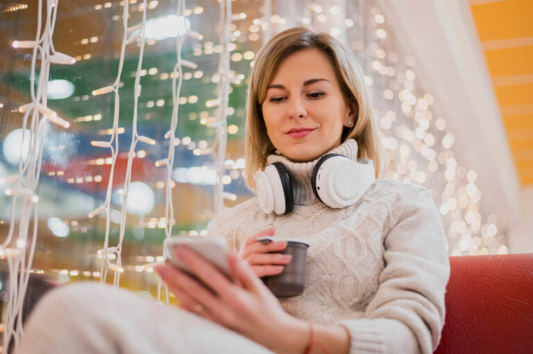 woman with headphones around neck near christmas lights