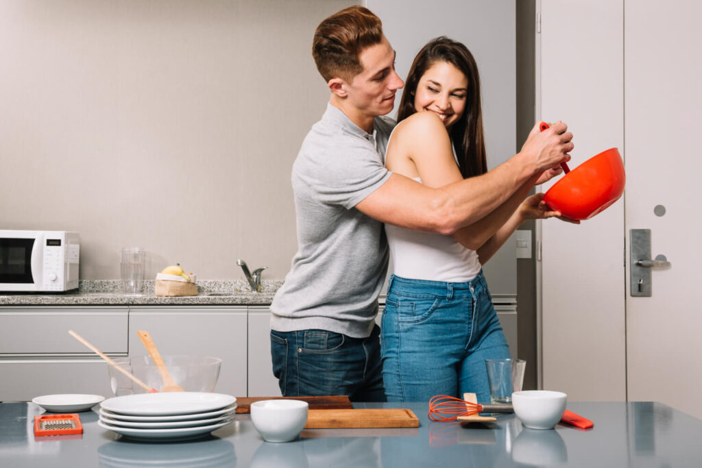 man helping woman with mixing food bowl