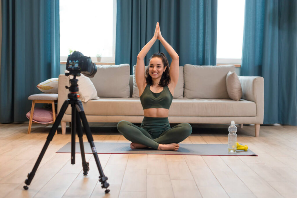 sporty blogger sitting lotus position with arms up