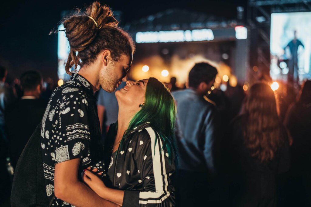 young happy couple kissing music festival