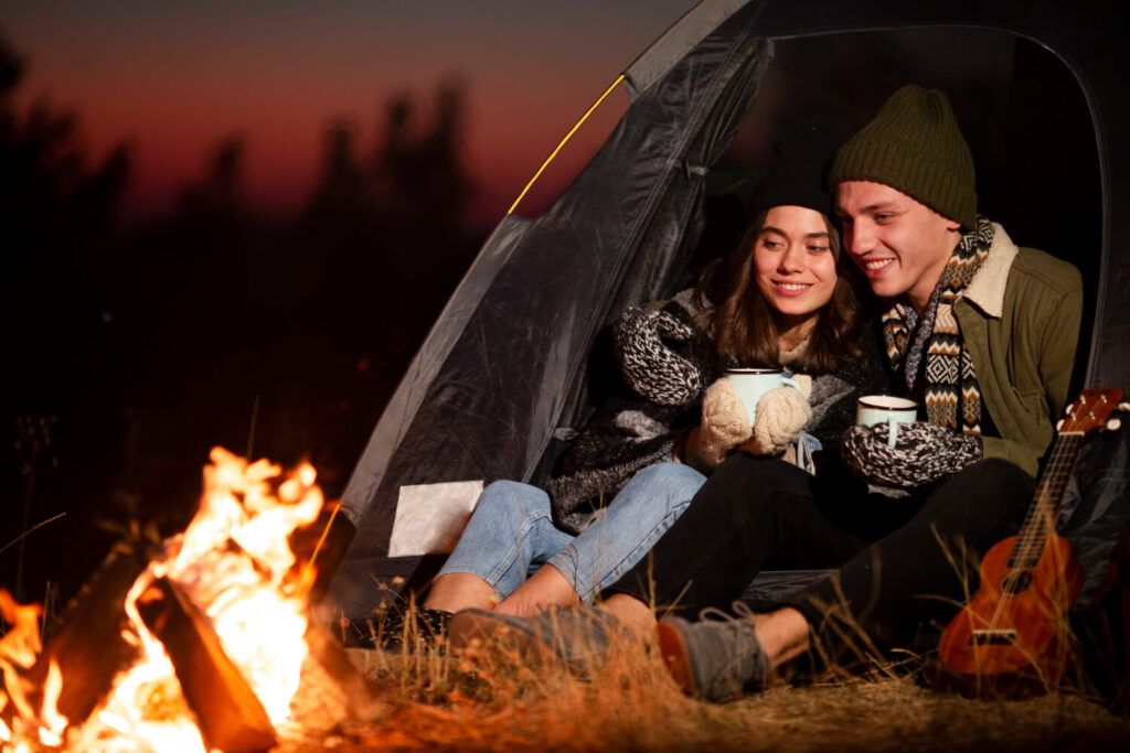 young man woman enjoying bonfire