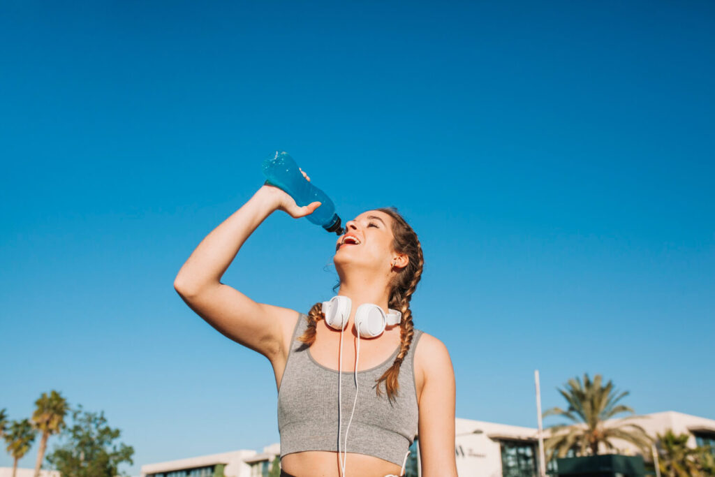 athletic woman enjoying blue drink