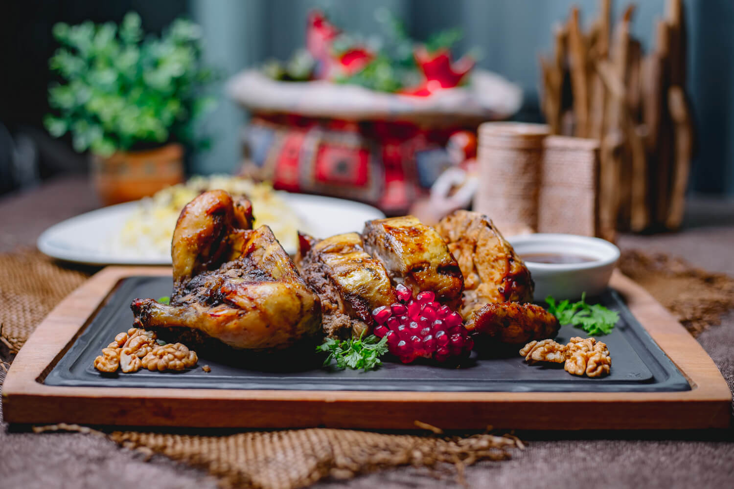 roasted stuffed chicken decorated with pomegranate walnuts black board rice white plate wooden table