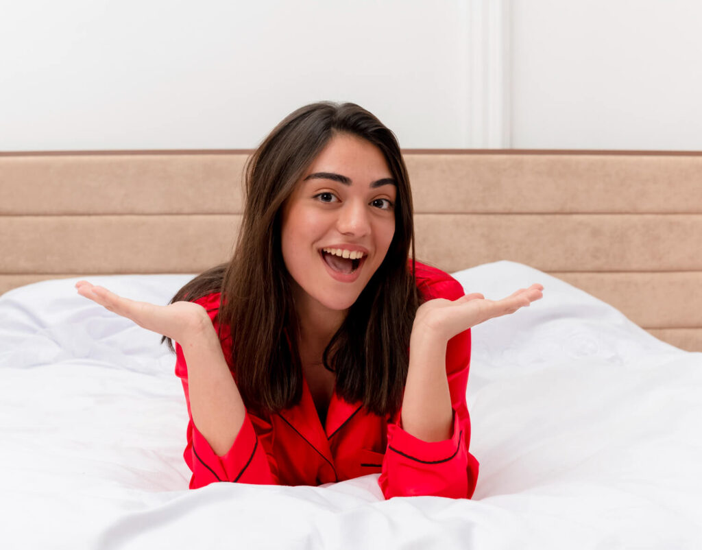 young beautiful woman red pajamas relaxing laying bed smiling with happy face
