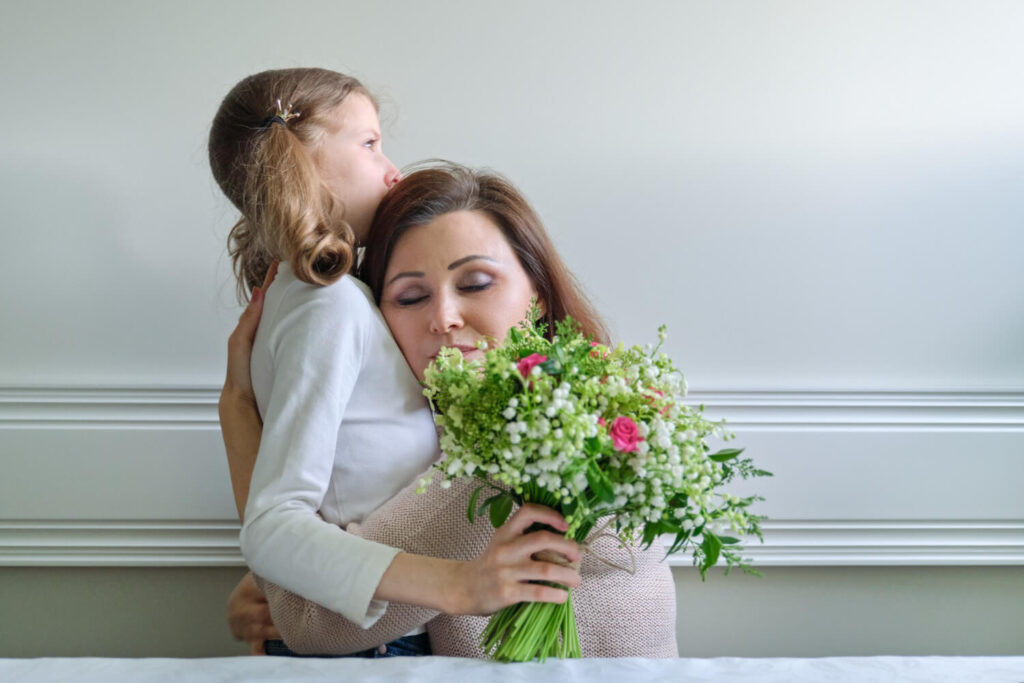 little girl gifting bouquet to her mother on mother's day