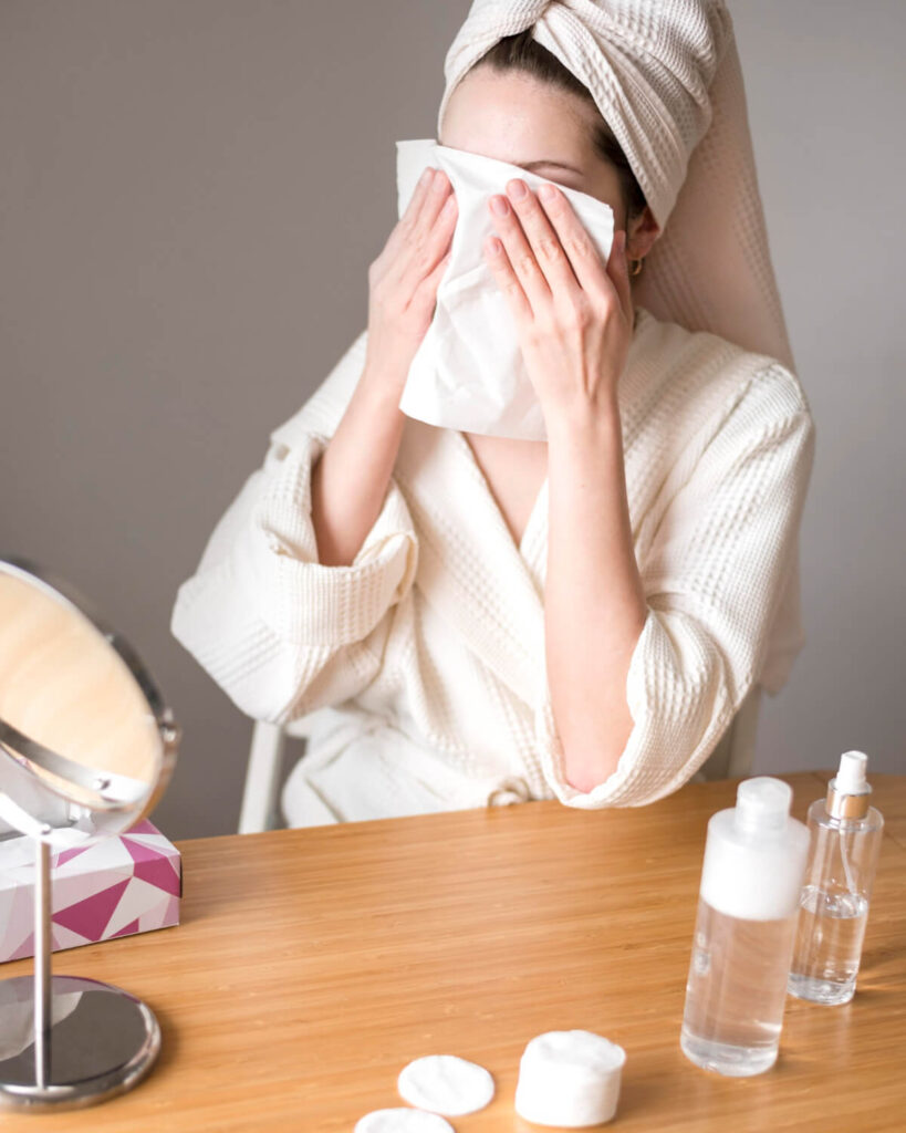 woman using micellar water remove make up