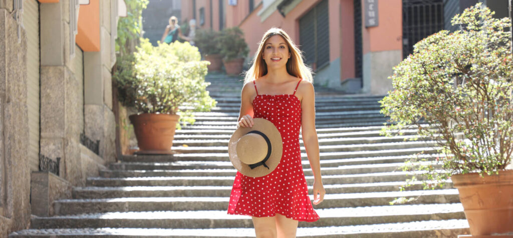 girl wears Italian Summer dresses and hat in her hand