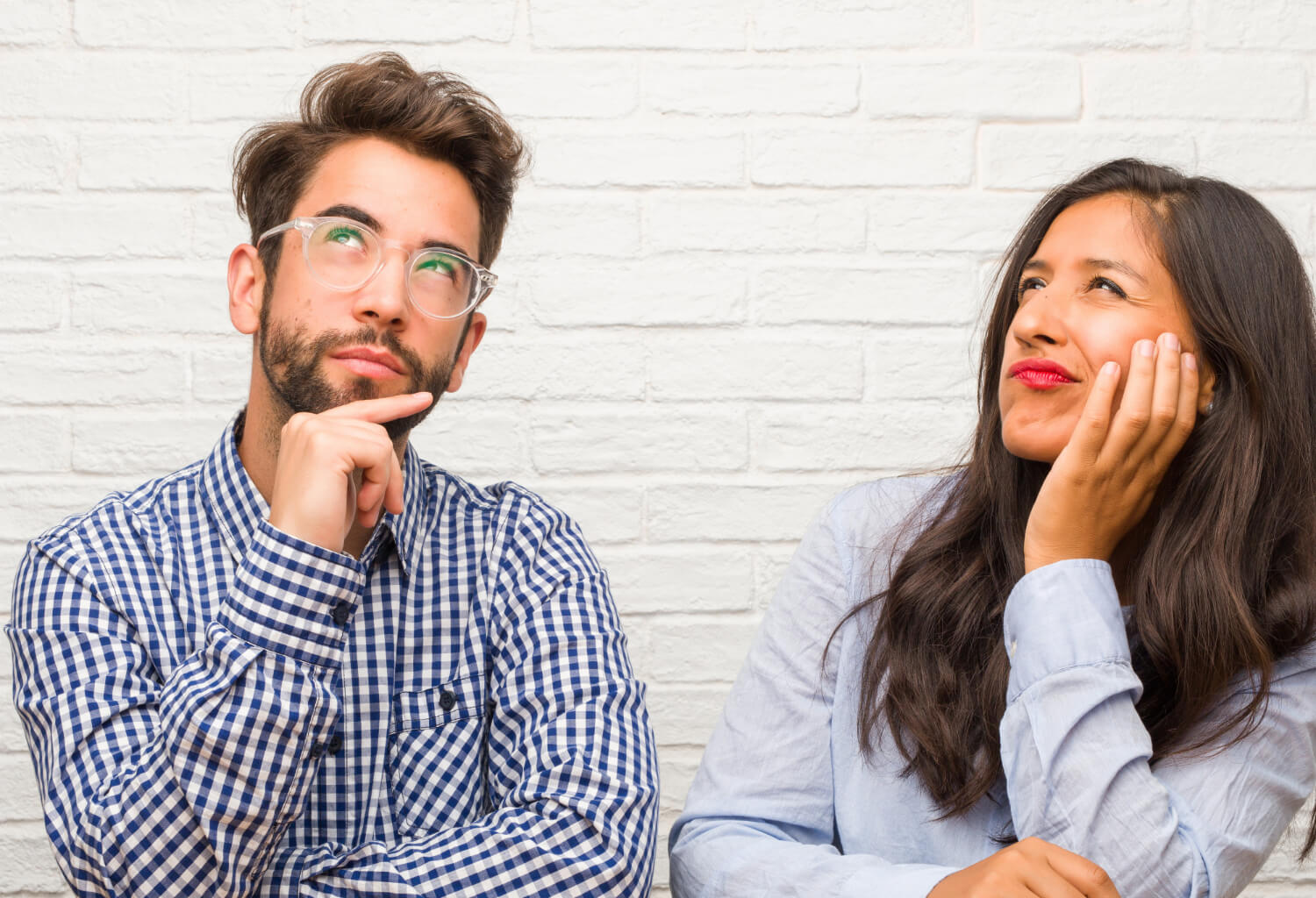 young indian woman caucasian man couple thinking looking up confused about idea