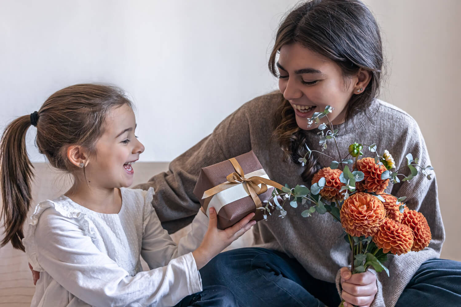 little girl gives her mom gift box bouquet chrysanthemum flowers concept mother s day birthday women s day: What to get Mom for Christmas