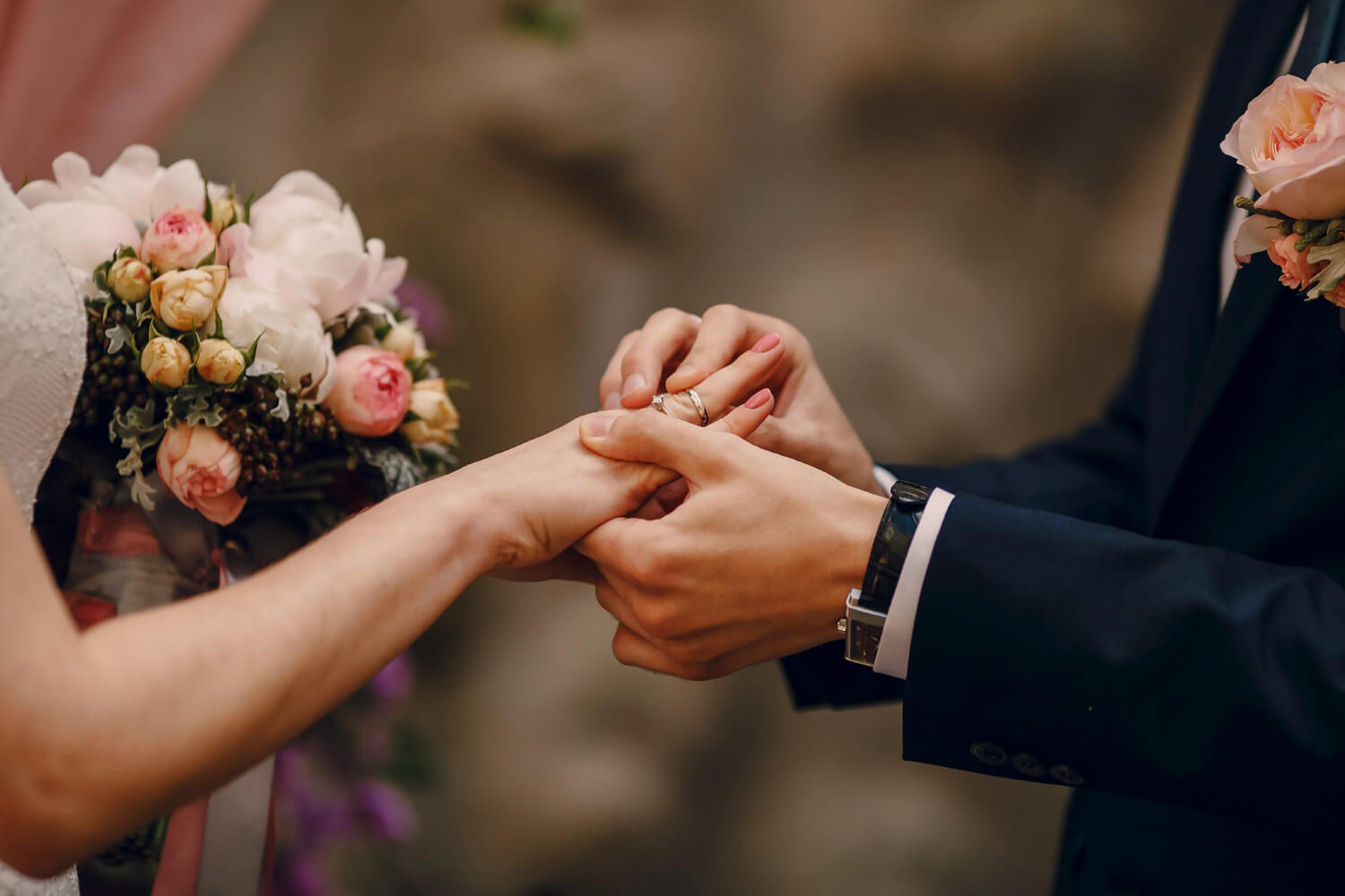 groom putting ring brides finger