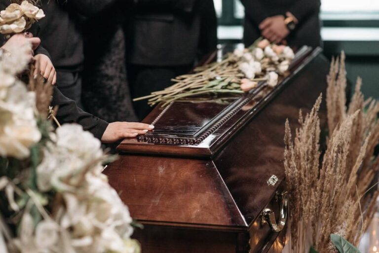 a person holding a wooden coffin: What to Wear to a Funeral